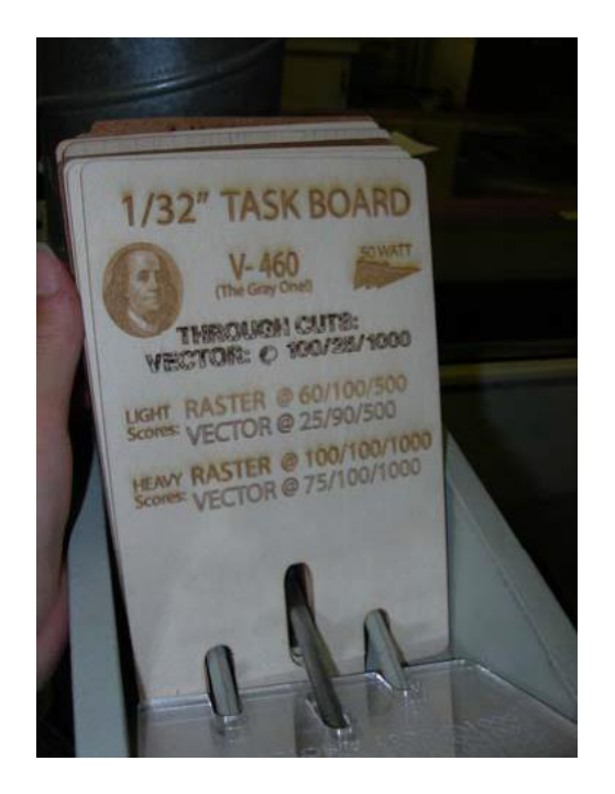 Box of sample cut cards with a 1/32 inch task board card listing through cut, light raster, medium raster and heavy raster settings