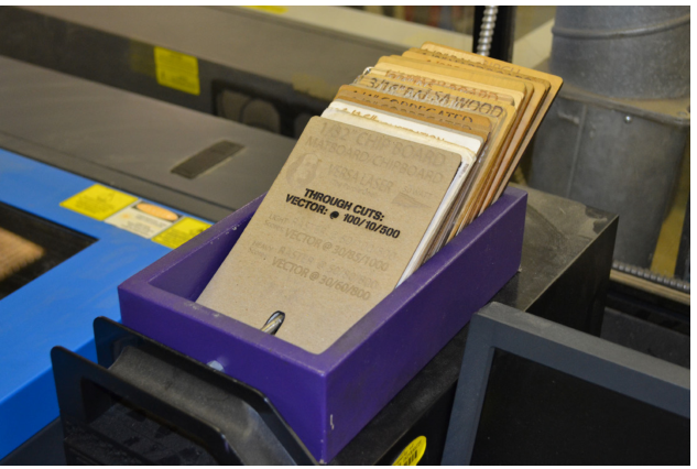Box of material index cards sitting on top of a laser cutter